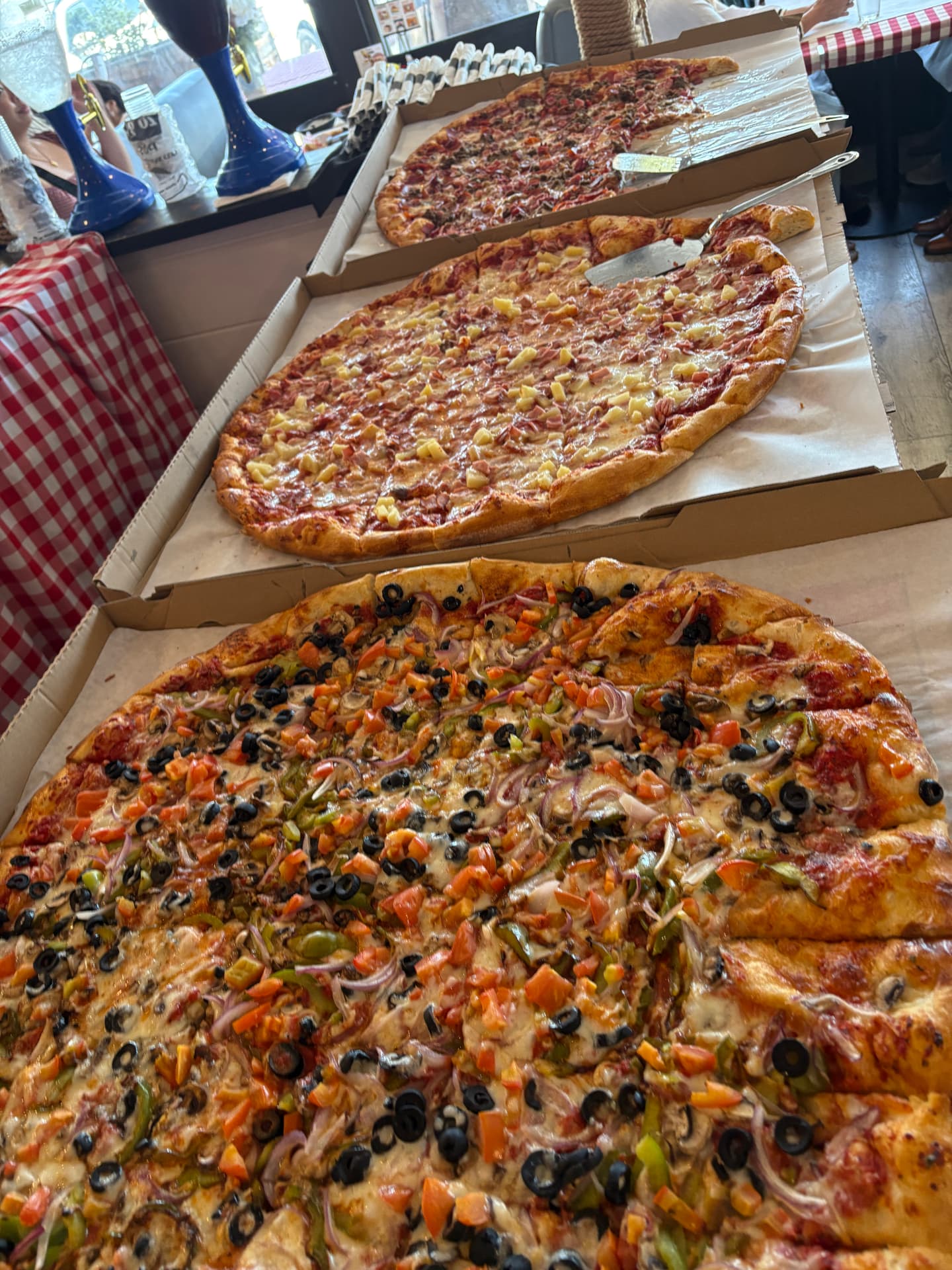 Large party pizzas lined up for a group