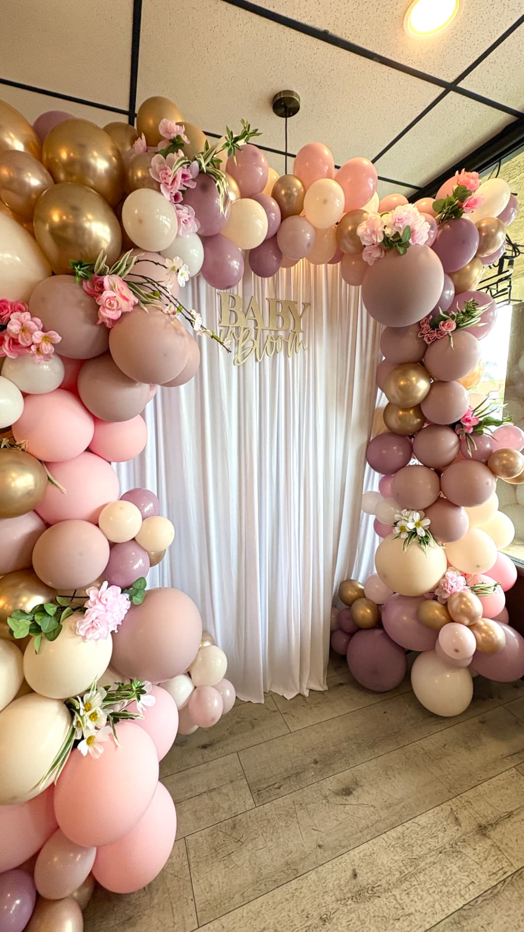 Baby shower balloon arch with Baby in Bloom sign