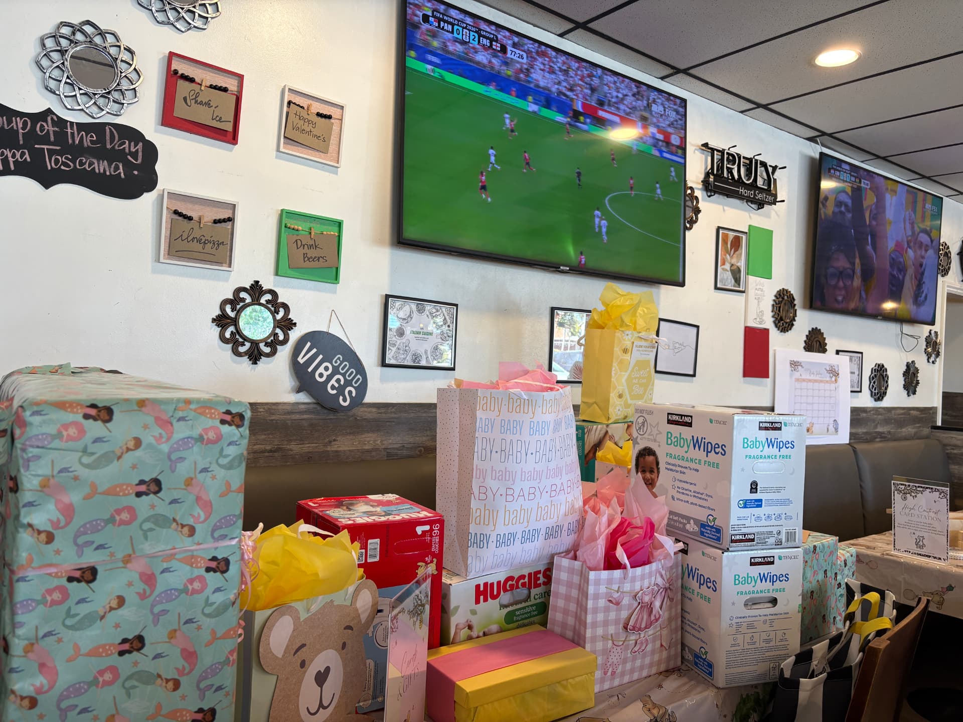 Baby shower gifts under the TVs showing live sports